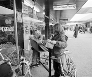 858425 Afbeelding van twee meisjes die een bak met grammofoonplaten bekijken bij de platenwinkel van Max van Praag in ...